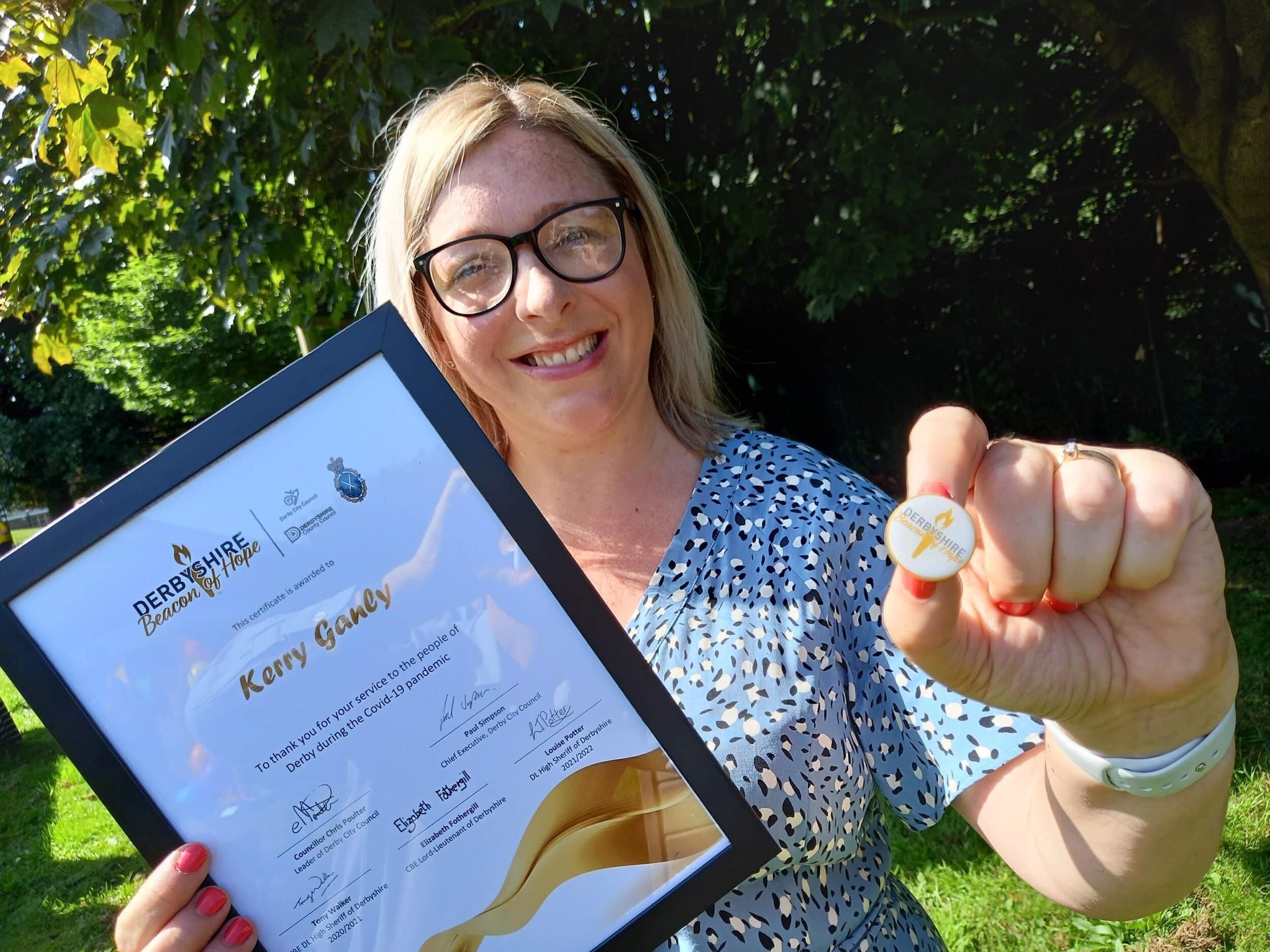 Kerry Gangly with her Beacon of Hope certificate awards and badge.