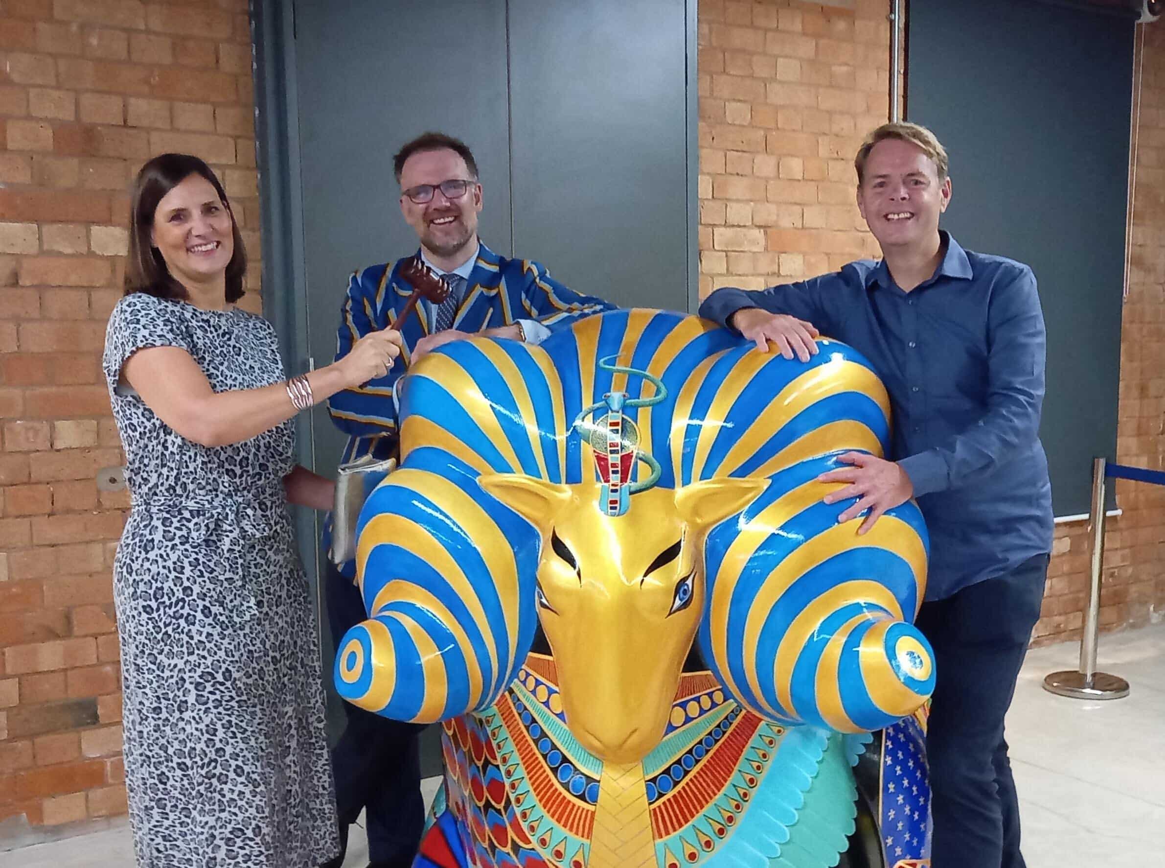 From left, Sarah Newton, director of Penguin PR, TV auctioneer Charles Hanson and Simon Burch, director of Penguin PR, with Rameses, one of 30 Derby Ram Trail sculptures sold at an auction night held last week to raise fund for the Derby Museums Trust.