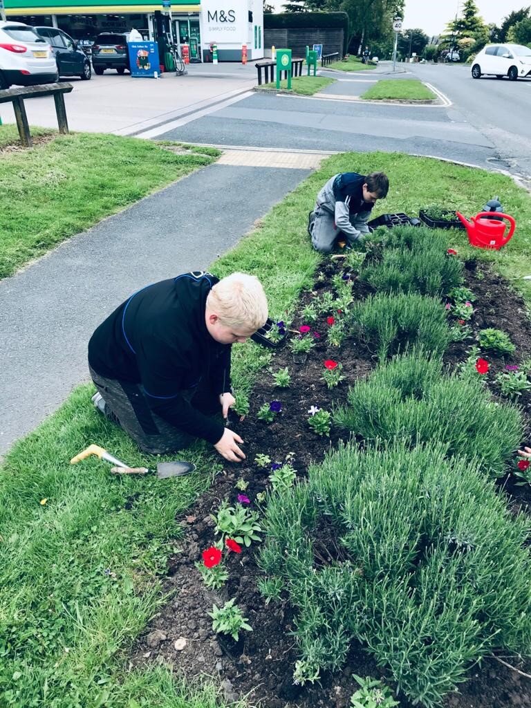 Dan Austin, 15, weeding an planting flowers in Derby community.