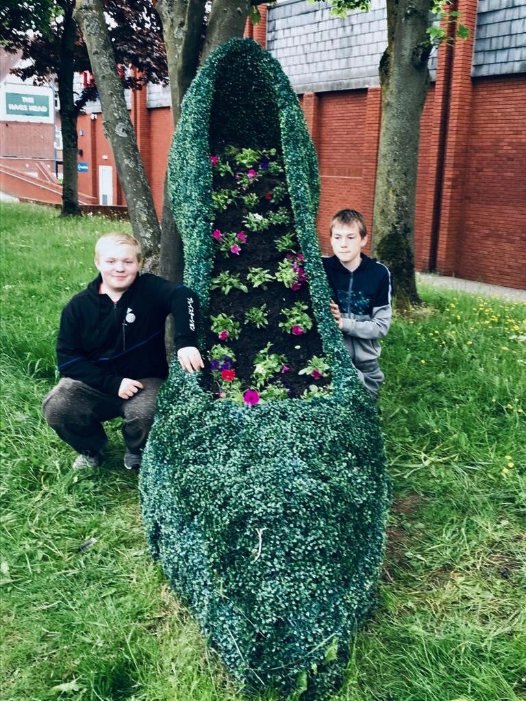 Dan and friend next to flower bed they had weeded and arranged.