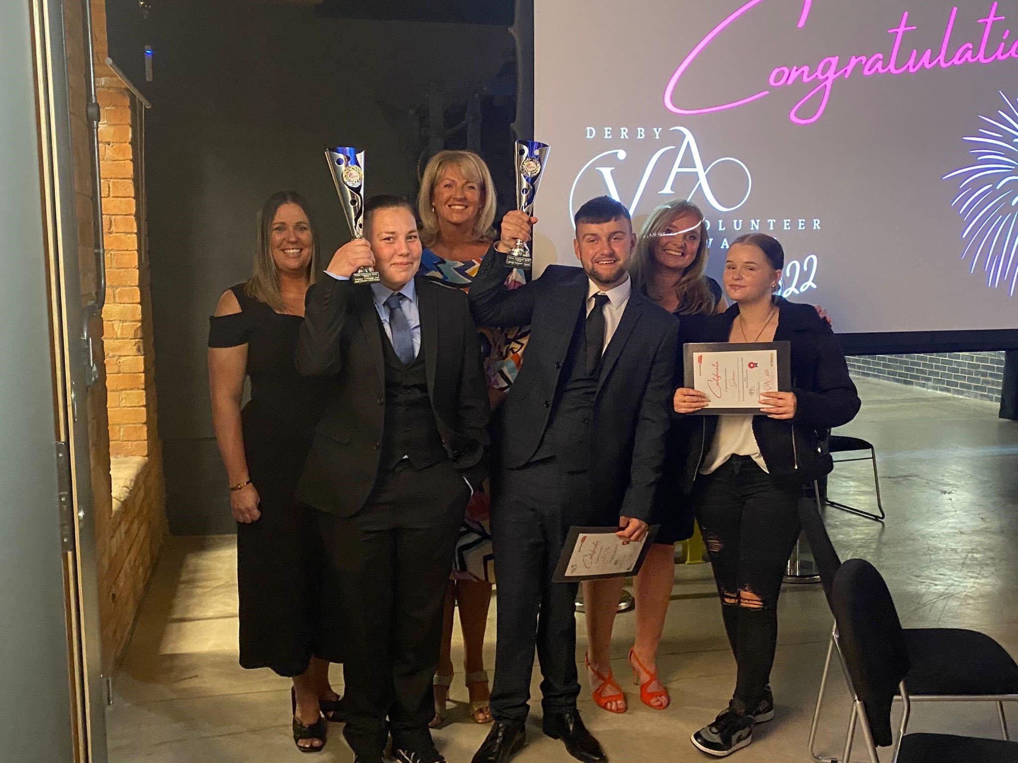 A group of staff and volunteers from Enthusiasm – April Allman and Aaron Payne holding the two awards.