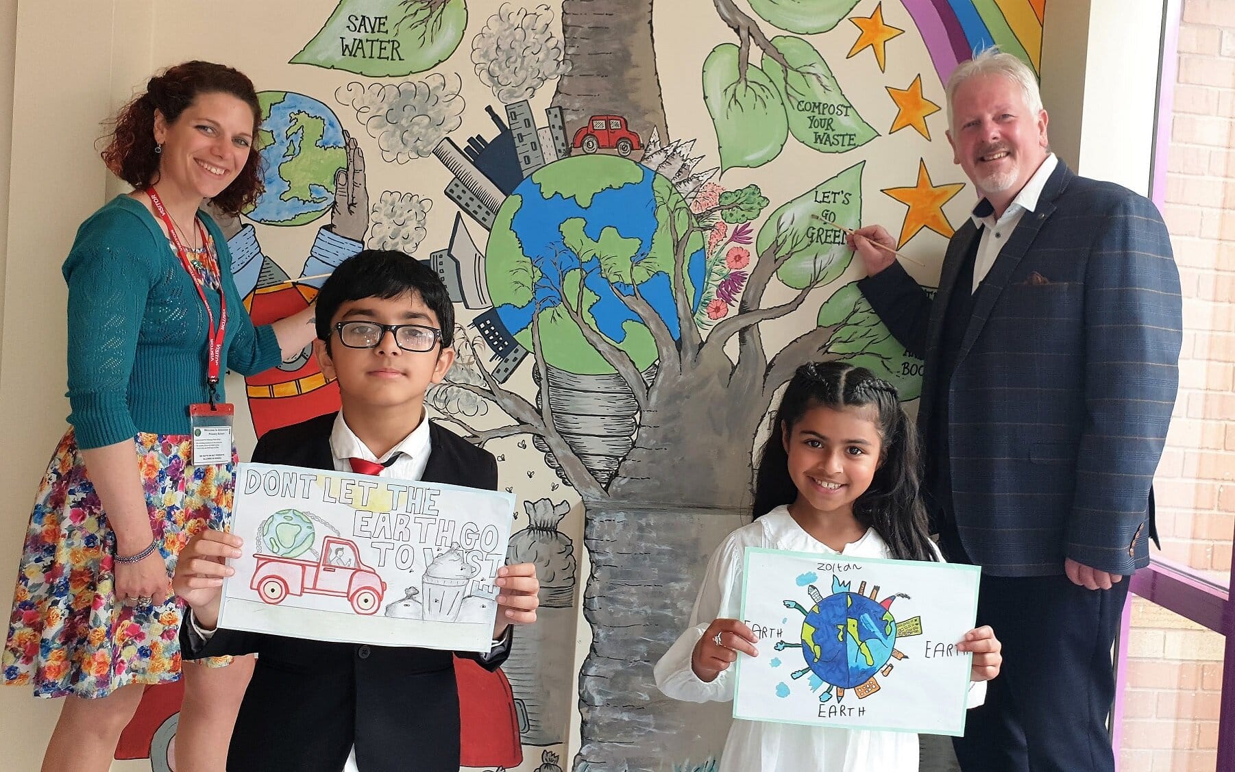 Seven-year-old Ibrahim Raja and Zoya Mehmood with Claire Hollinghurst, quality system manager at Lubrizol. and Arboretum Primary School head teacher Nigel Daintith put the final touches to the school’s mural.