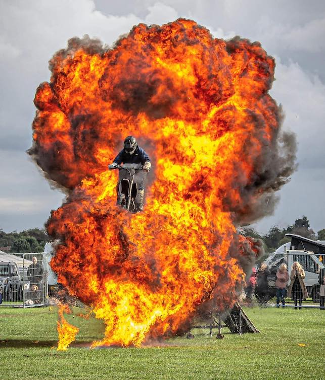 This is an image of a bike riding stunt man performing a trick riding thought a fire run