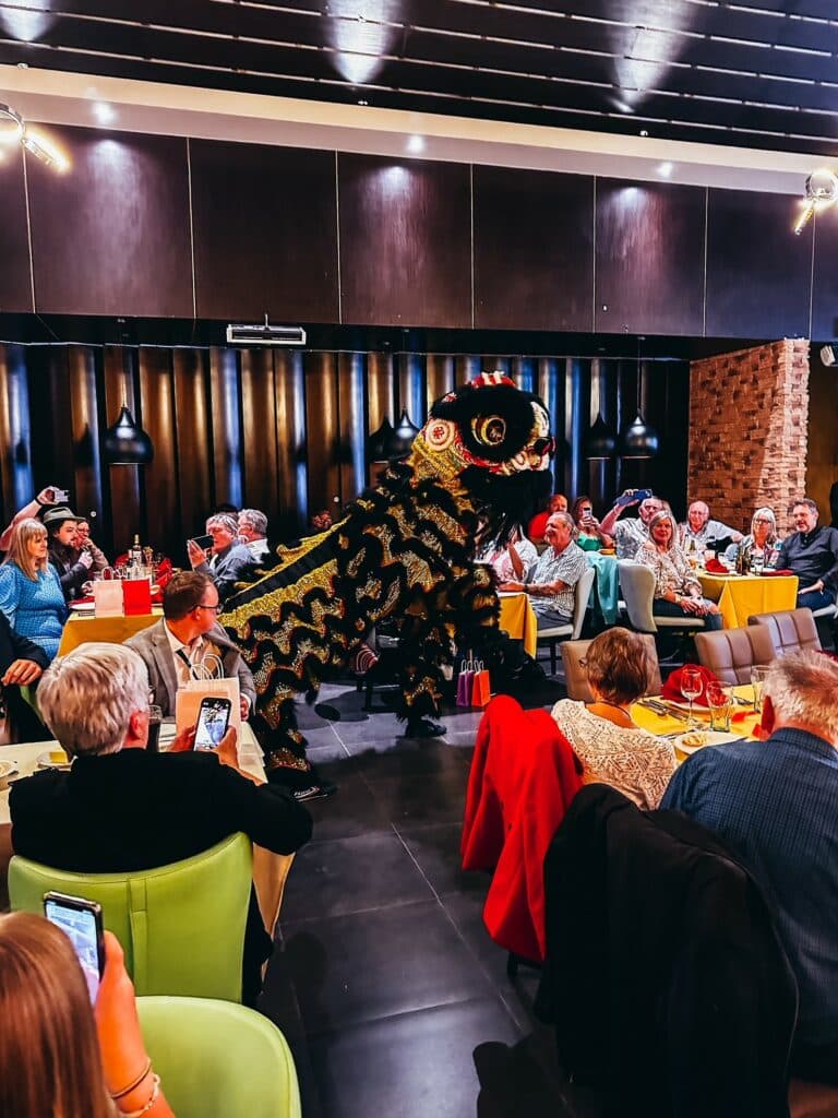 A dancing Chinese Lion entertaining guests at a restaurant celebration