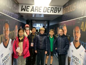 Children stand in the tunnel at Derby County Football Club.