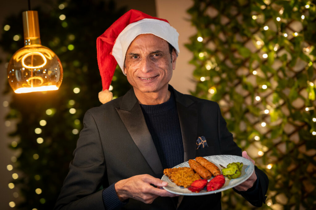 Ali Khan, founder of Kitchen 7 Indian Restaurant in Shardlow, wearing a Santa hat as he reveals it is almost fully booked for Christmas