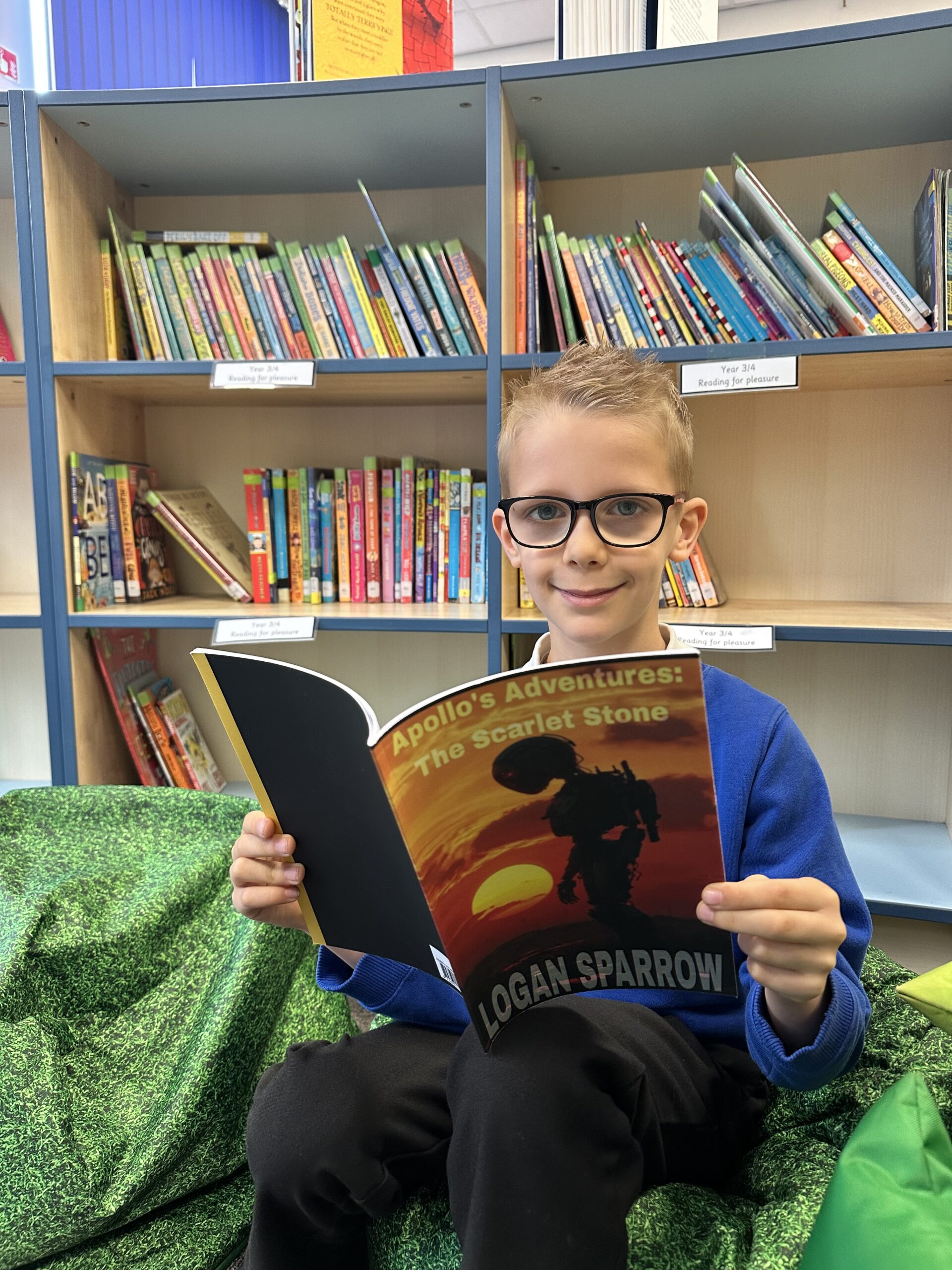 Boy pictured holding book in school library