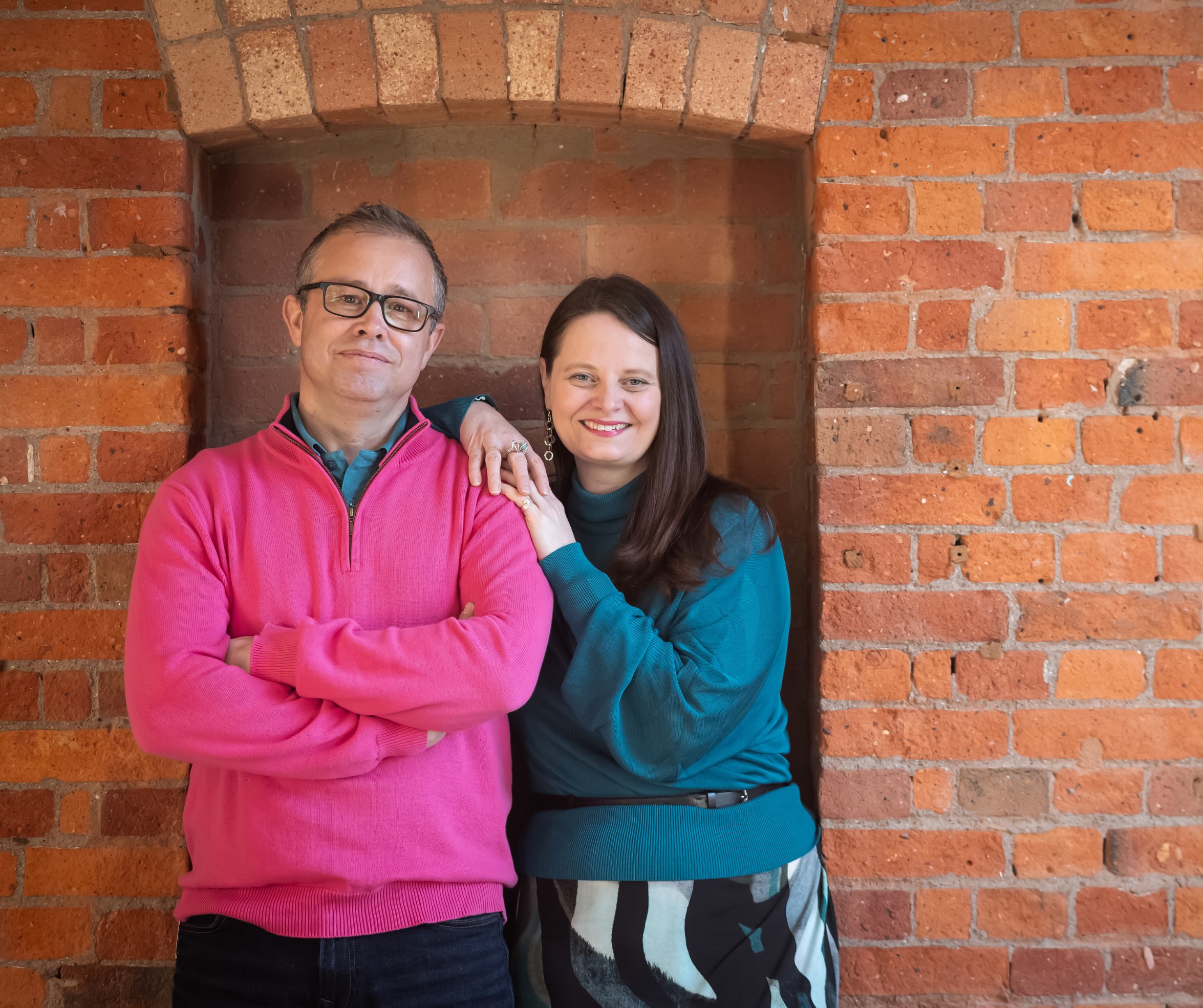 picture of Q Branch founders Matt and Jenny in front of a brick wall