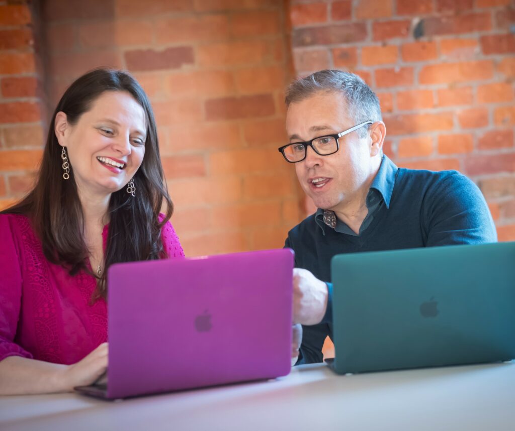 owners of Q branch Jenny and Matt using their laptops 