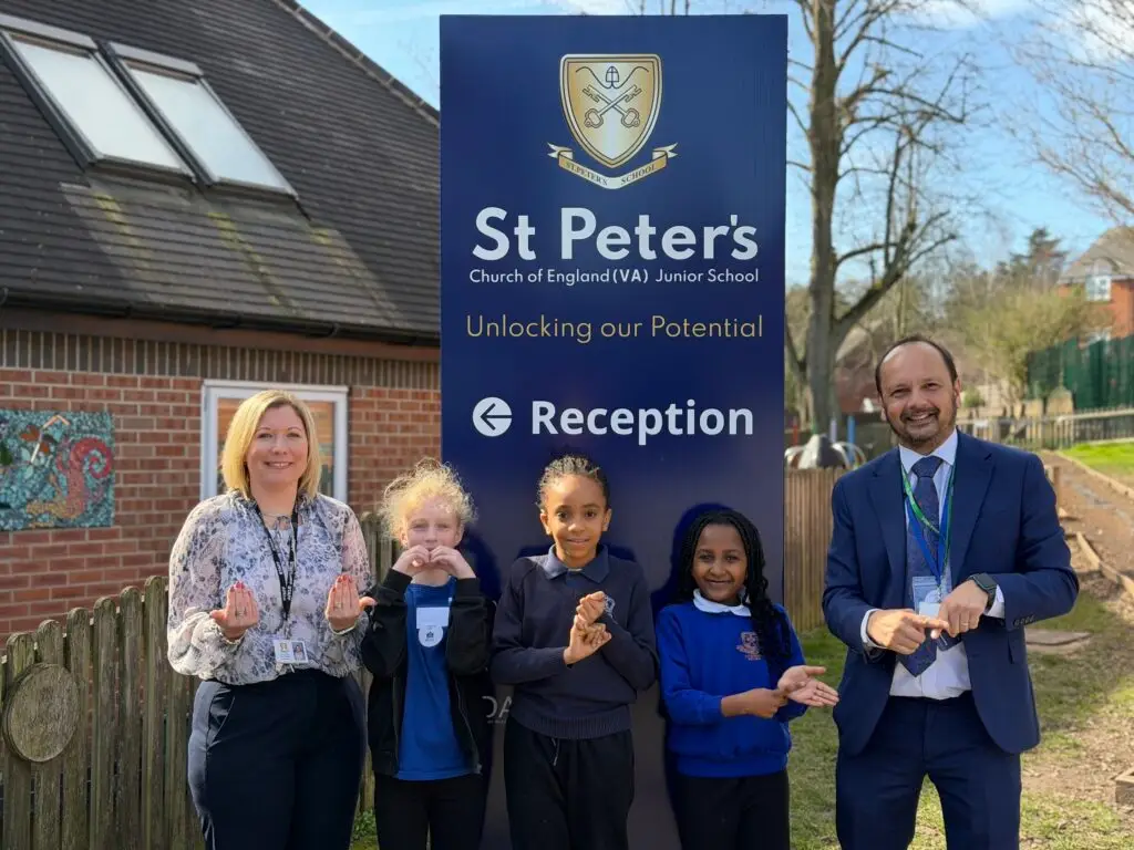 St Peters headteacher Helen Reader with RSDD headteacher Paul Burrows and pupils signing 'Welcome to BSL week"