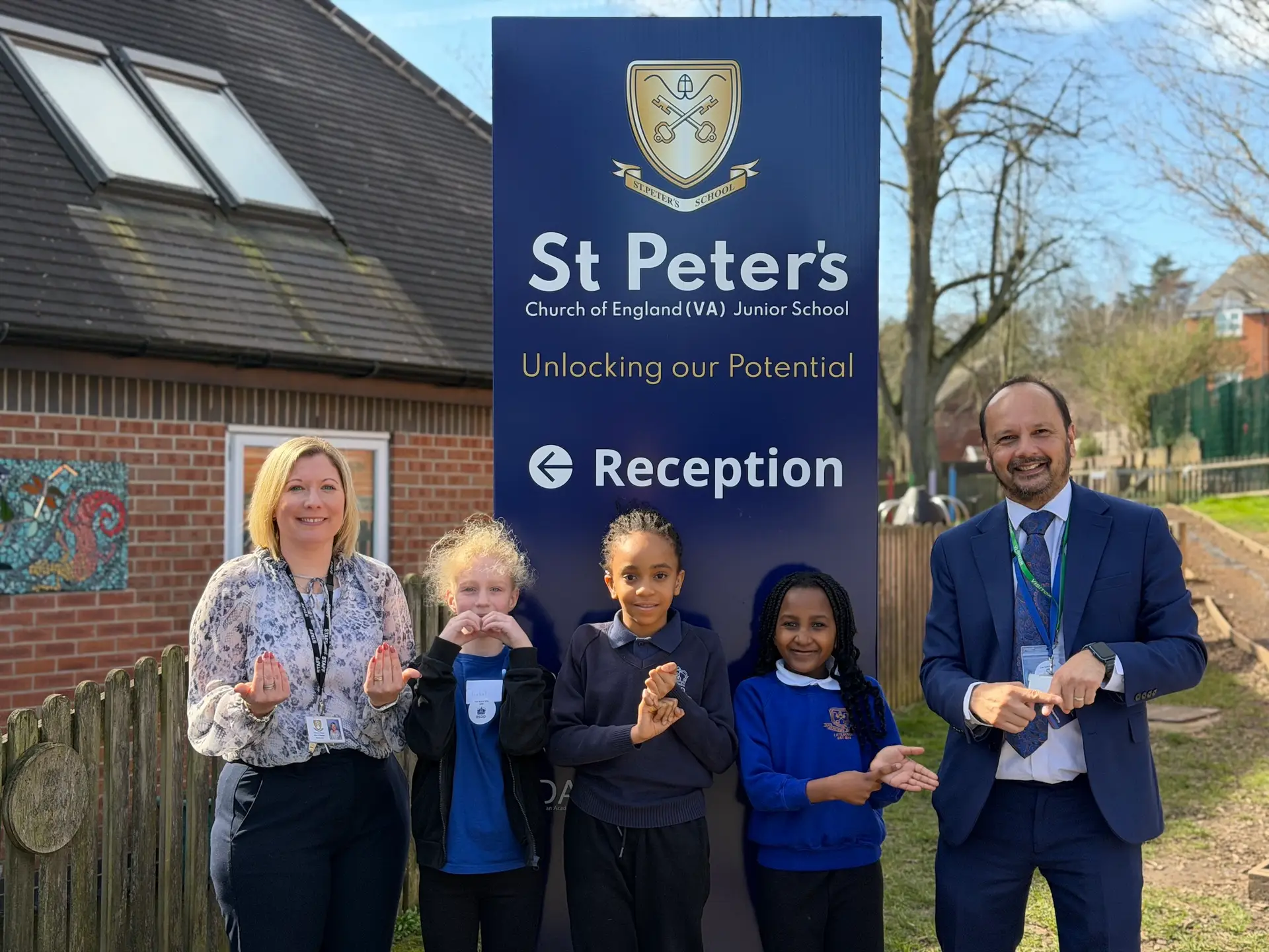 St Peters headteacher Helen Reader with RSDD headteacher Paul Burrows and pupils signing 'Welcome to BSL week"