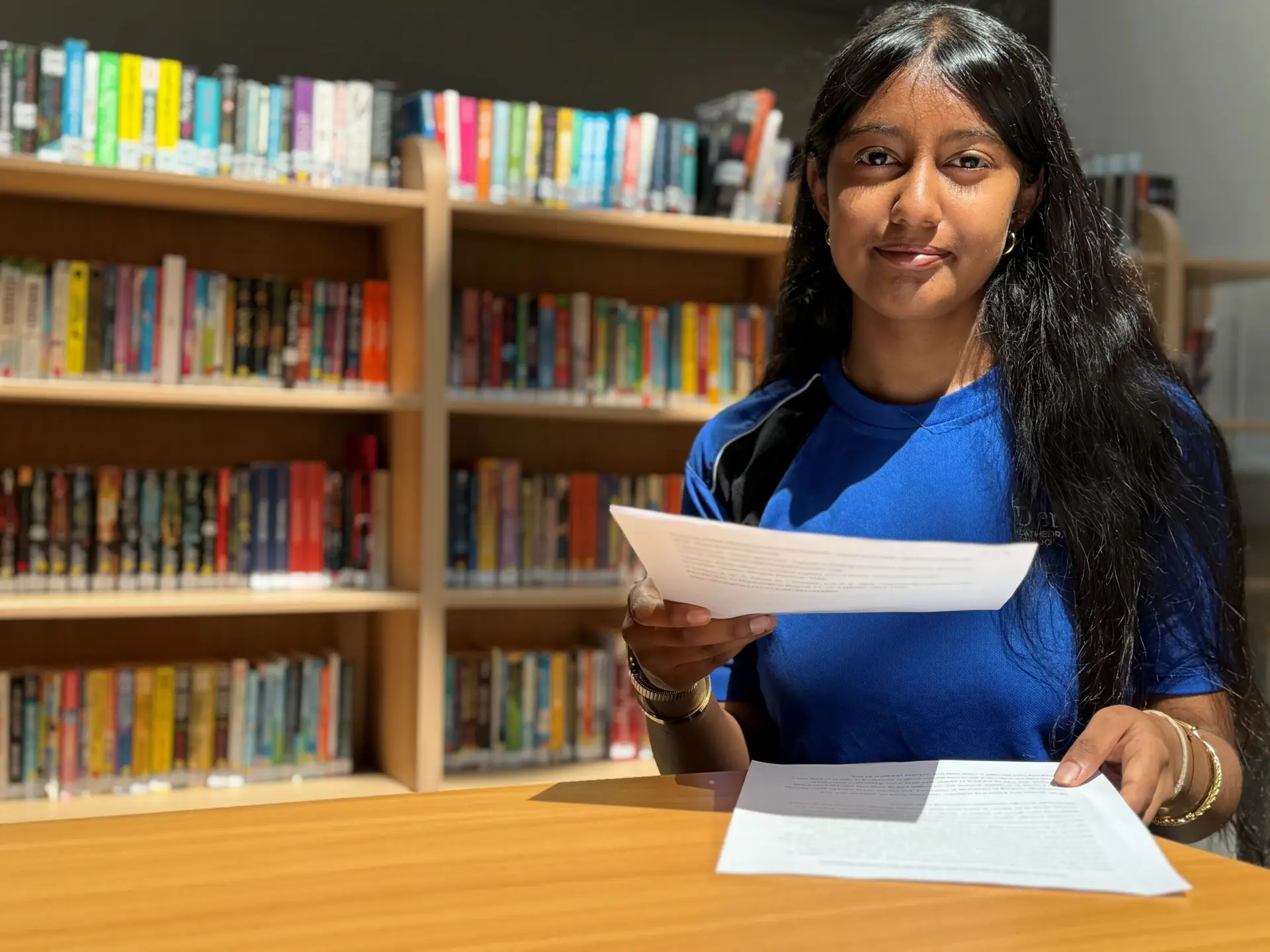 Derby Cathedral School pupil Haleema Rifki holding her shortlisted John Locke Global Essay Prize entry in the school library.