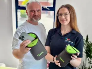 L.E.A.D IT Services staff members hold Yondr phone pouches, demonstrating the secure phone-locking system.
