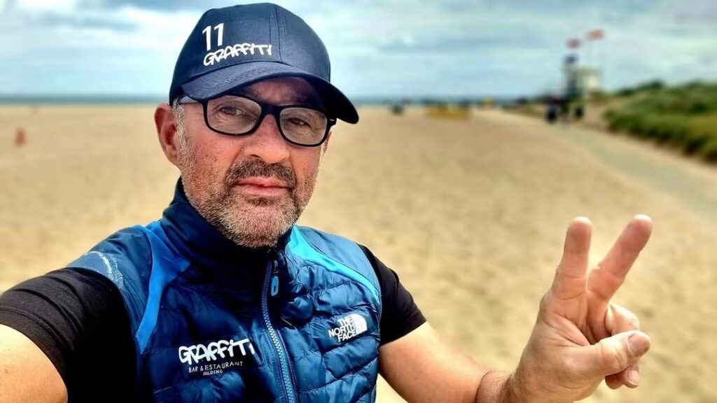 Grzegorz Pacho posing for a selfie on a beach. 