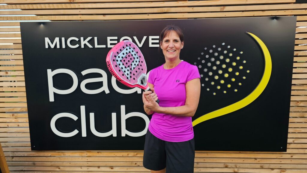 Sarah Newton holding a pink padel racket at the Mickleover Padel Club. 